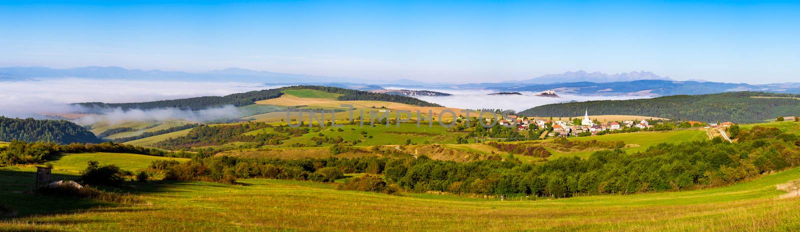 Panoramic view of traditional village, Spis castle, meadows and High Tatras mountain range, Slovakia