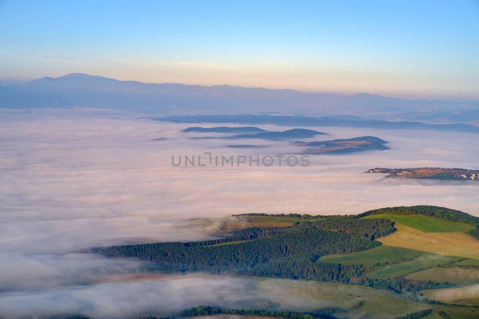 Beautiful landscape view of hills and meadows, mist and clouds by martinm303