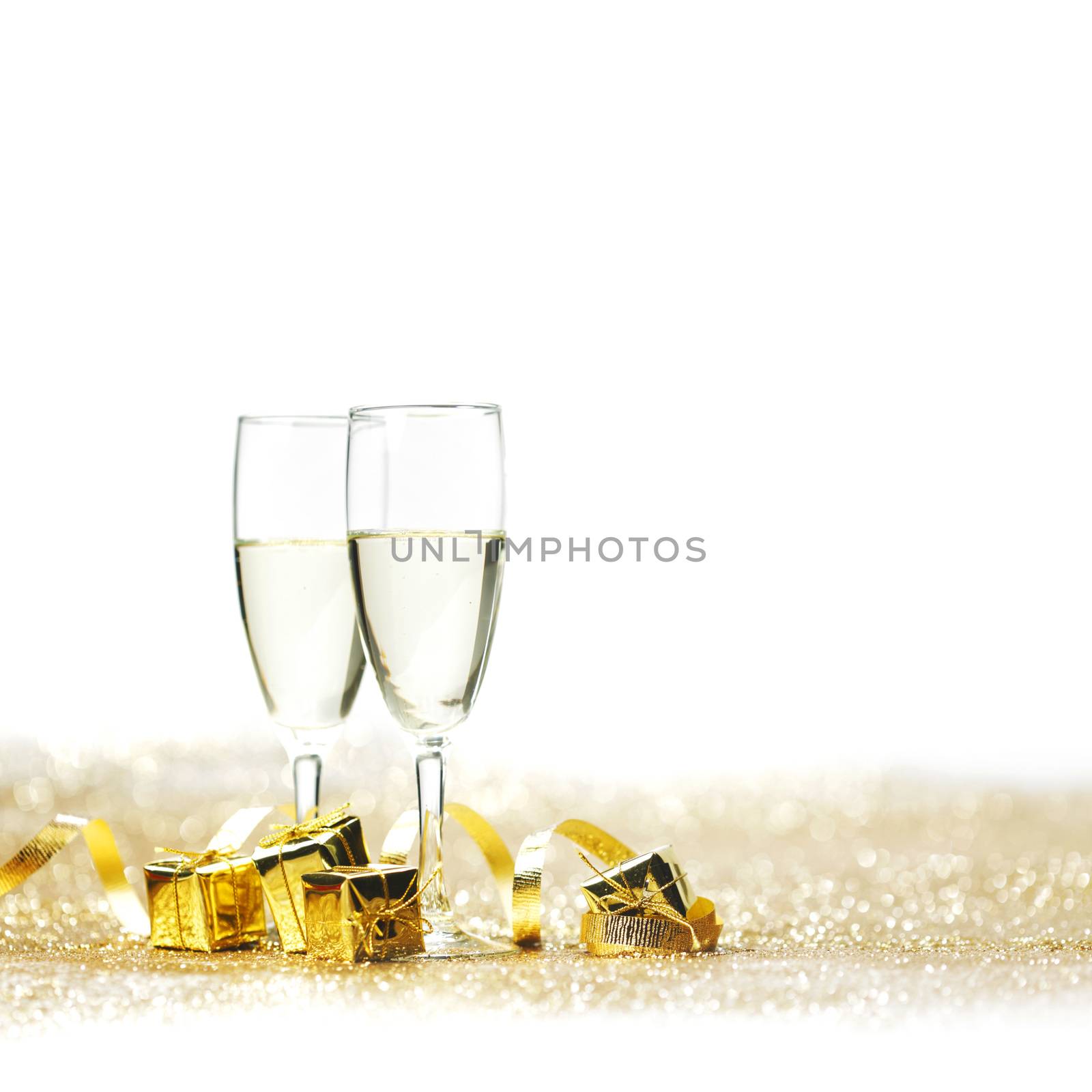 Champagne glasses and gifts on glitters with white copy space