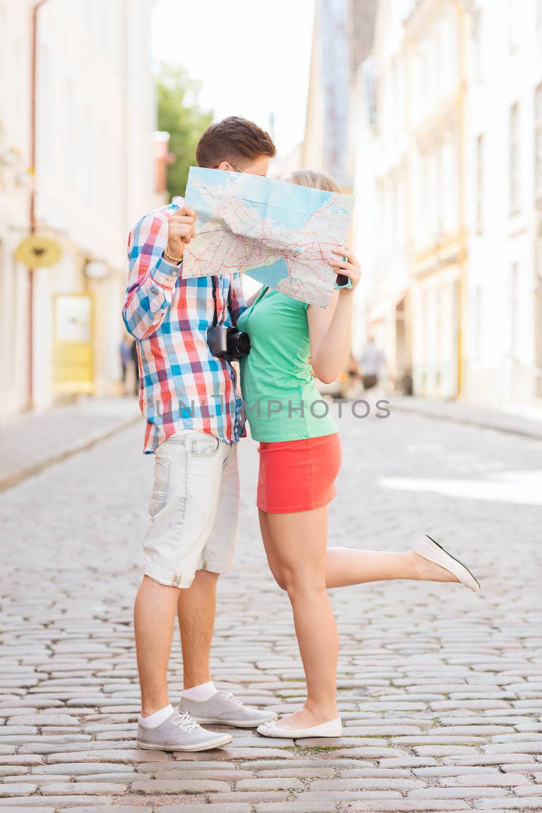 travel, vacation, technology and friendship concept - smiling couple with map and photo camera exploring city