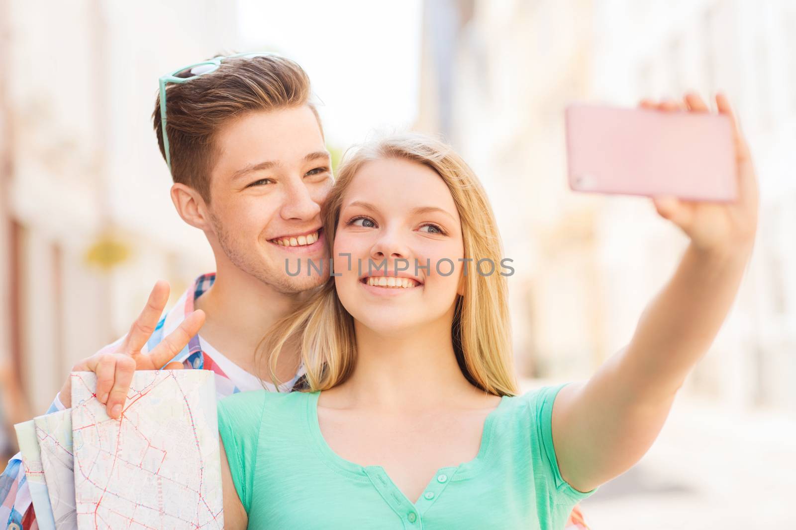 smiling couple with smartphone in city by dolgachov