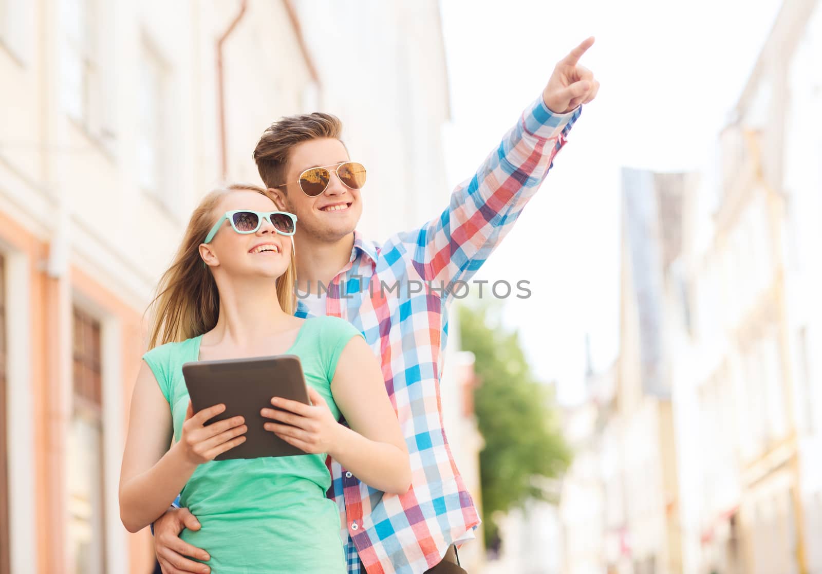 smiling couple with tablet pc in city by dolgachov