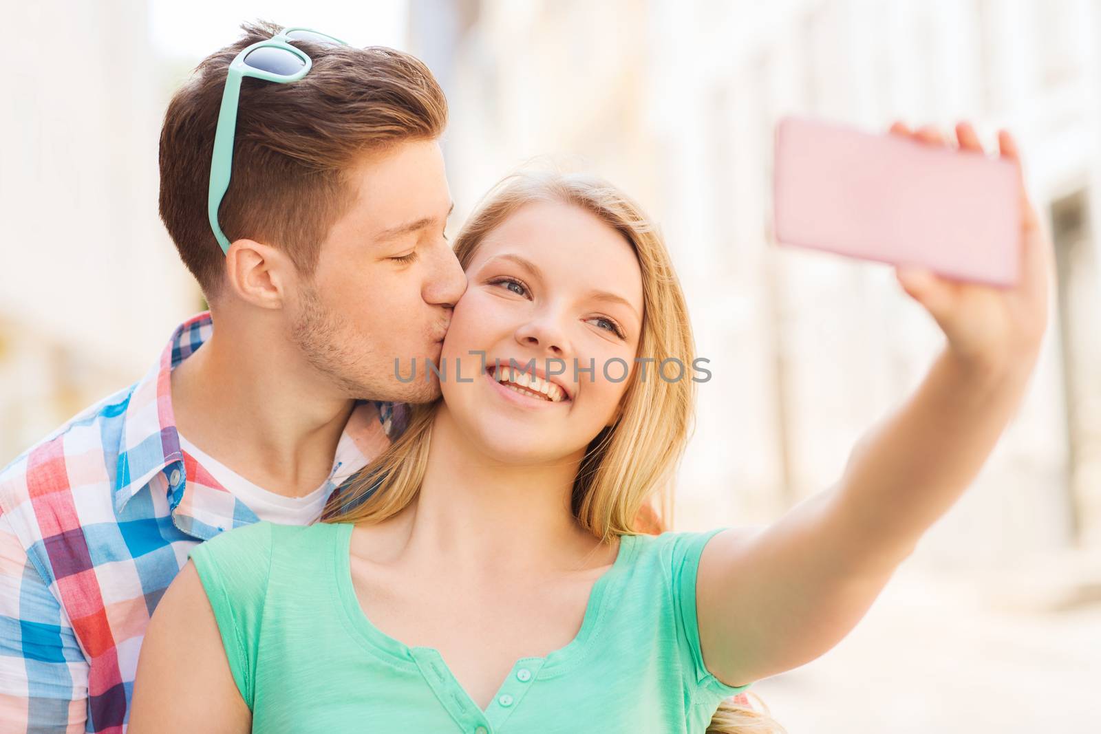 smiling couple with smartphone in city by dolgachov