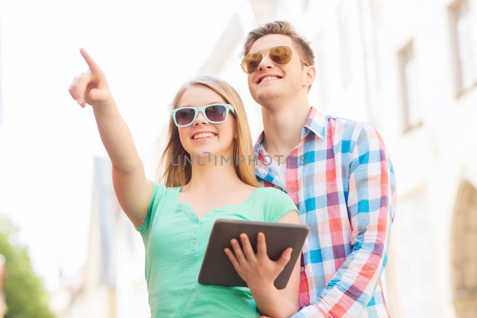 smiling couple with tablet pc in city by dolgachov