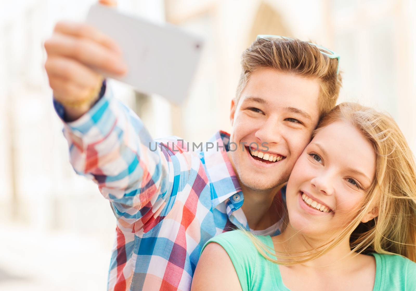 smiling couple with smartphone in city by dolgachov