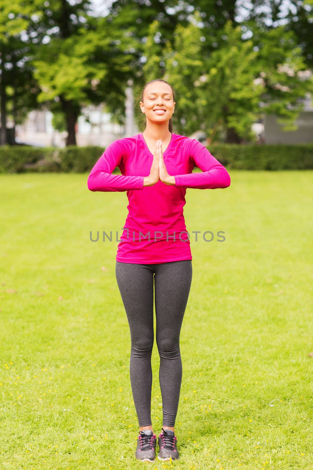smiling woman exercising outdoors by dolgachov