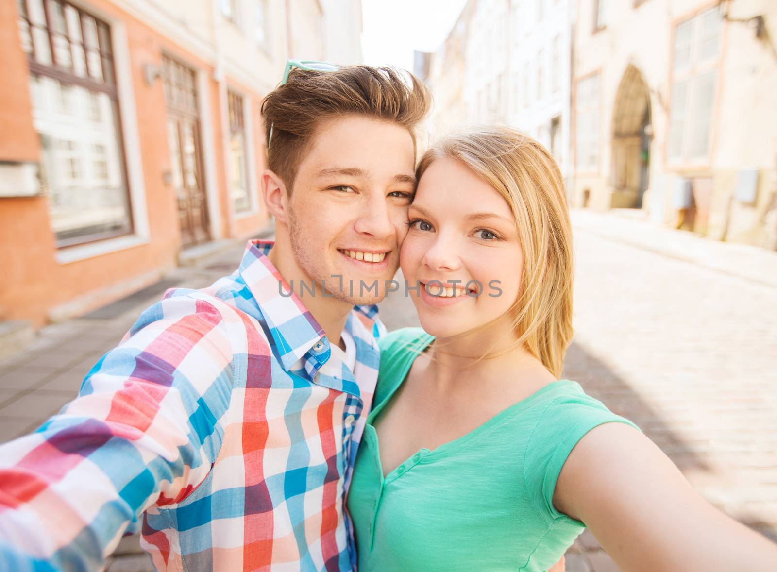 smiling couple with smartphone in city by dolgachov