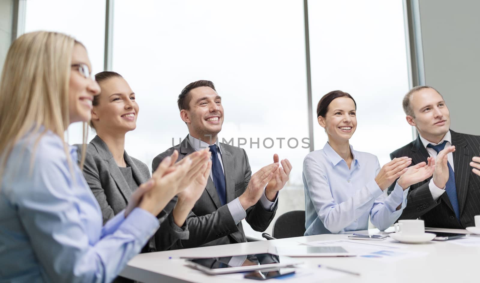 business team with laptop clapping hands by dolgachov