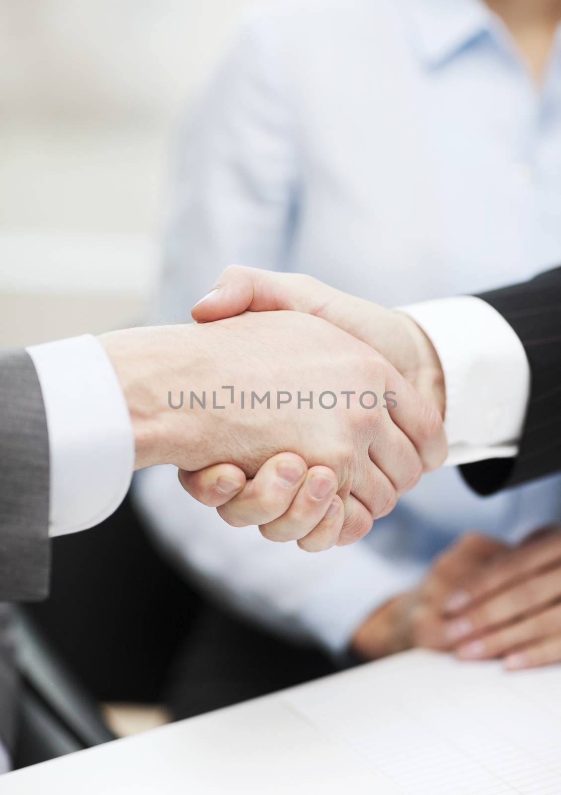 two businessmen shaking hands in office by dolgachov