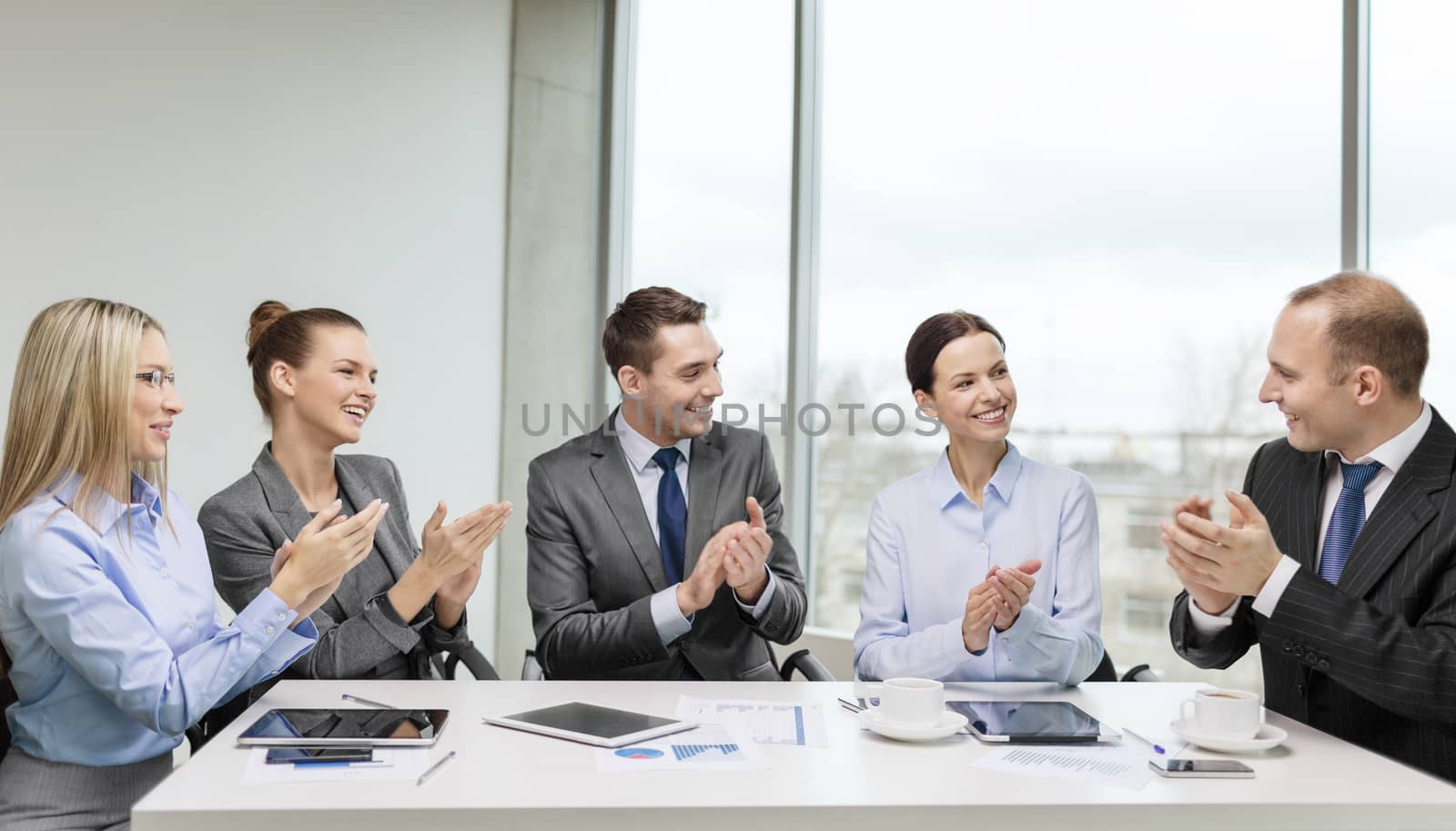 business team with laptop clapping hands by dolgachov