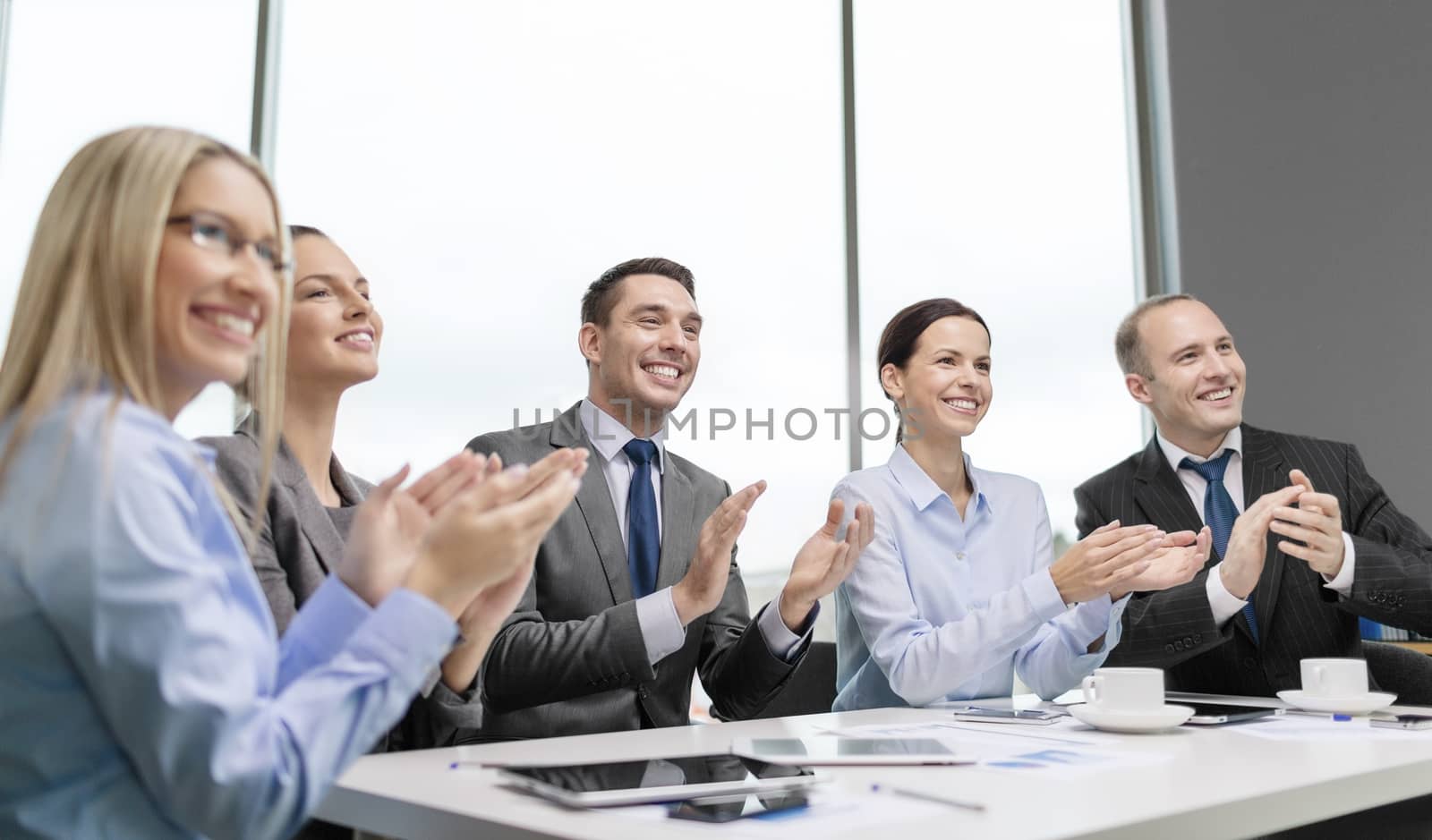 business team with laptop clapping hands by dolgachov