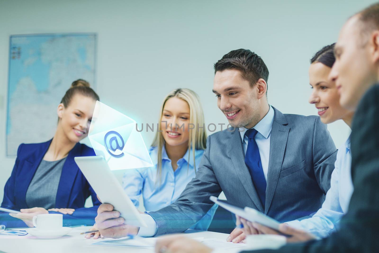 business, technology, communication and people concept - smiling business team with tablet pc computer and virtual message icon projection having discussion in office