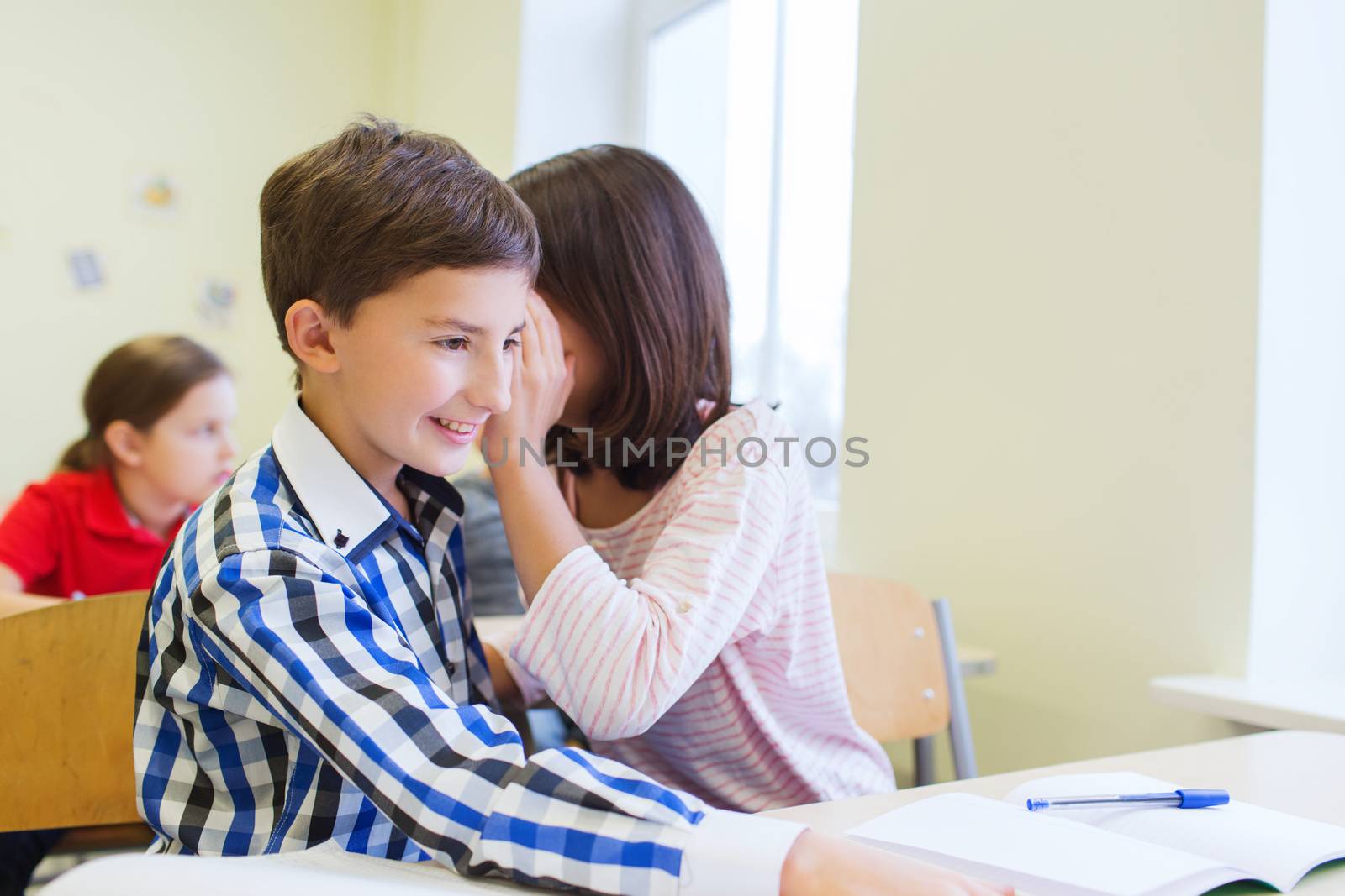 smiling schoolgirl whispering to classmate ear by dolgachov