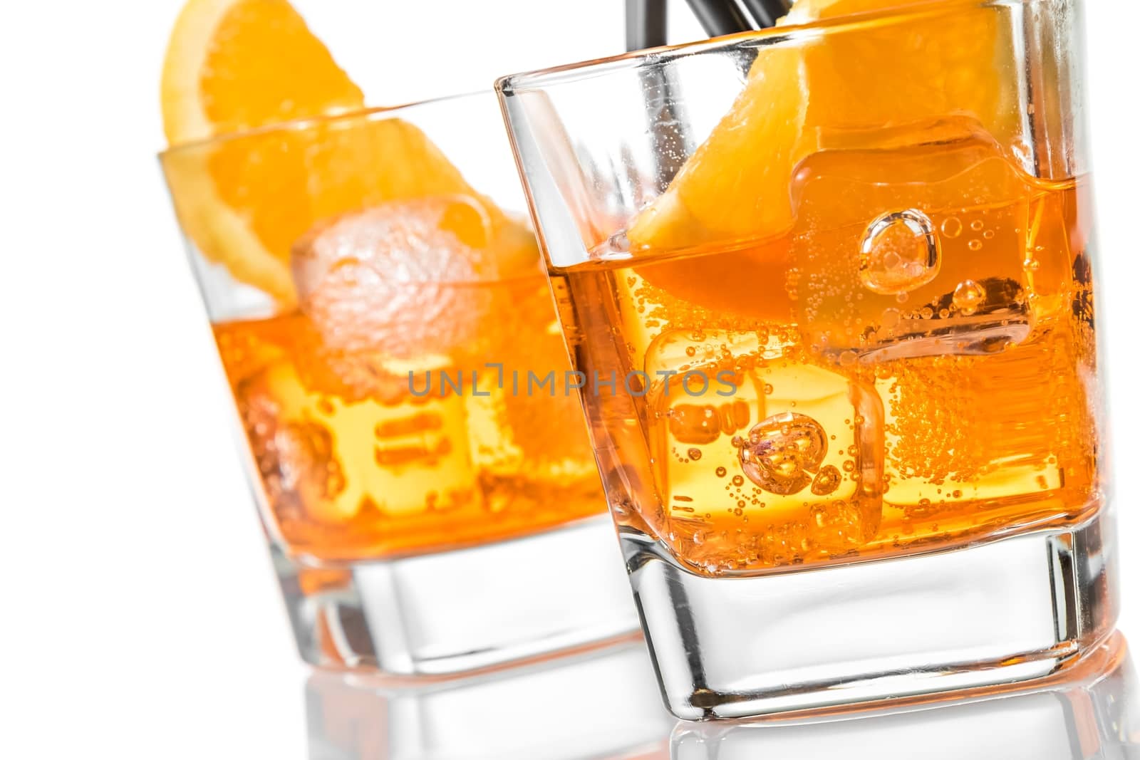 detail of two glasses of spritz aperitif aperol cocktail with orange slices and ice cubes on white background