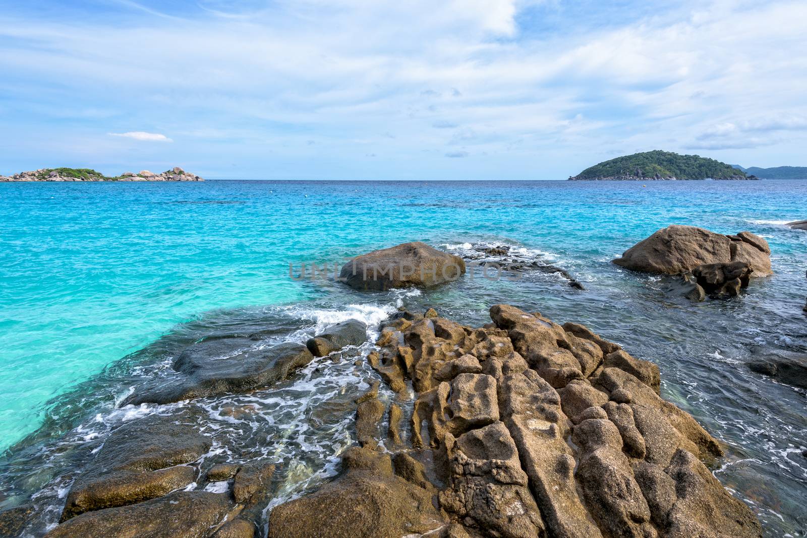 Beautiful landscape of blue sky sea and white waves on beach near the rocks during summer at Koh Miang island in Mu Ko Similan National Park, Phang Nga province, Thailand