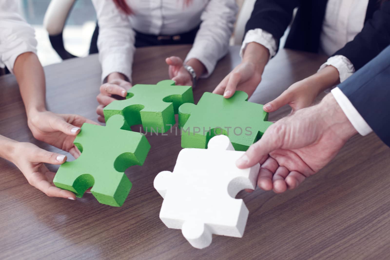 Business people assembling puzzle  by ALotOfPeople