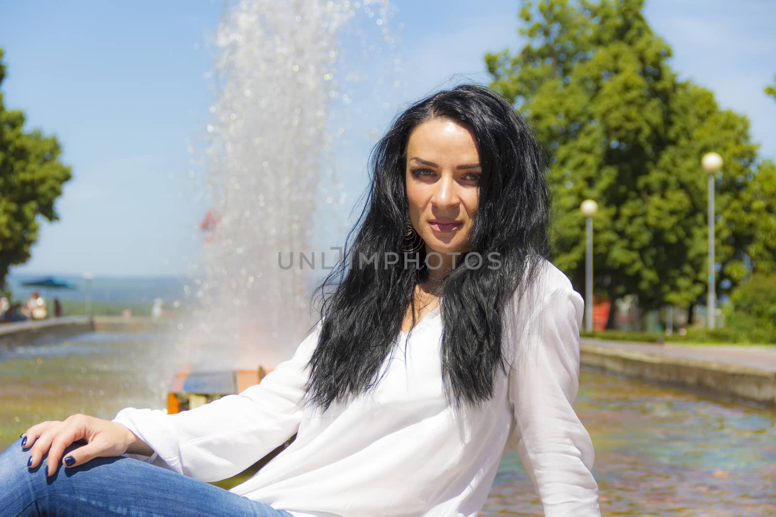 Photo of Caucasian brunette woman on fountain background