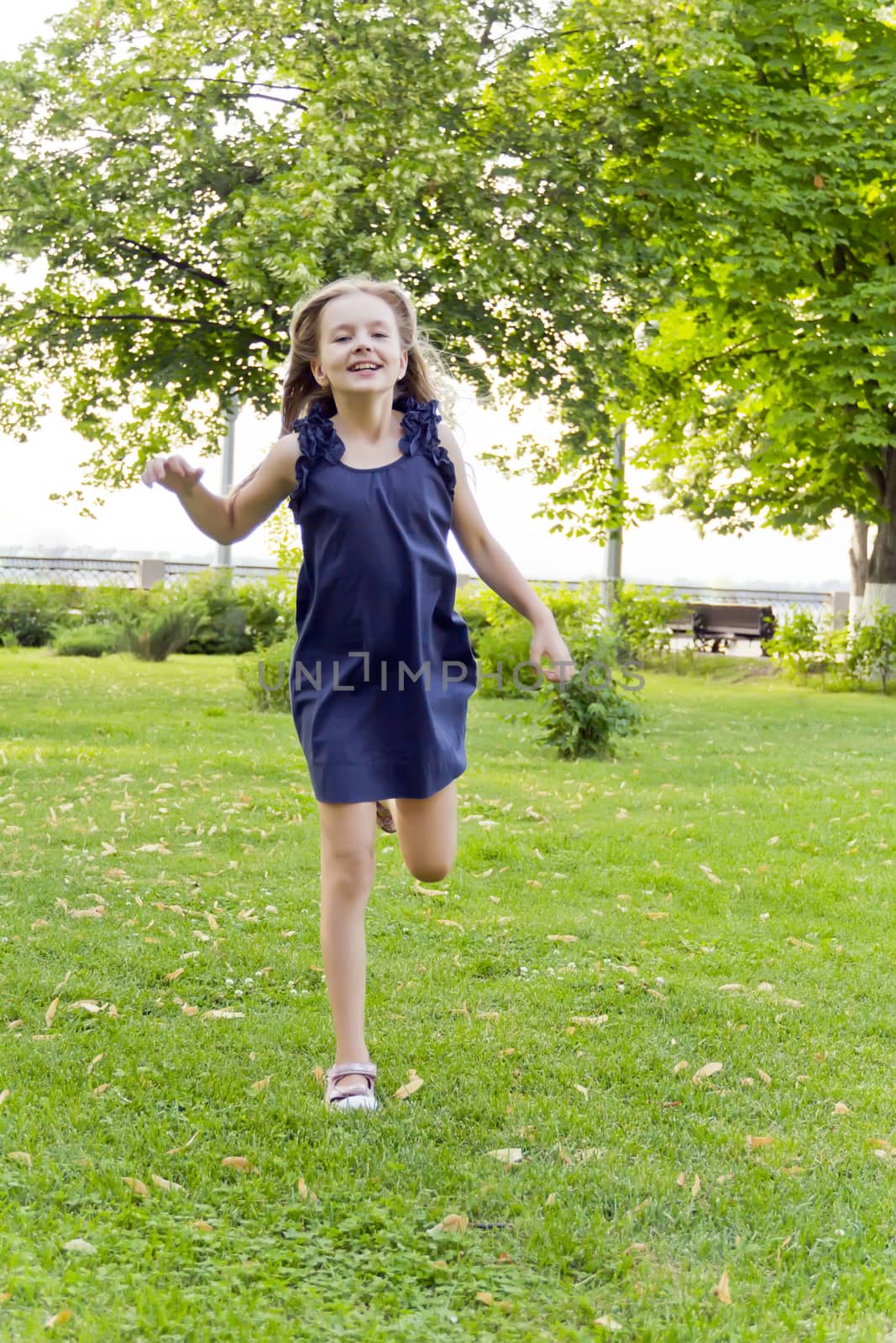 Girl is running in park on green grass