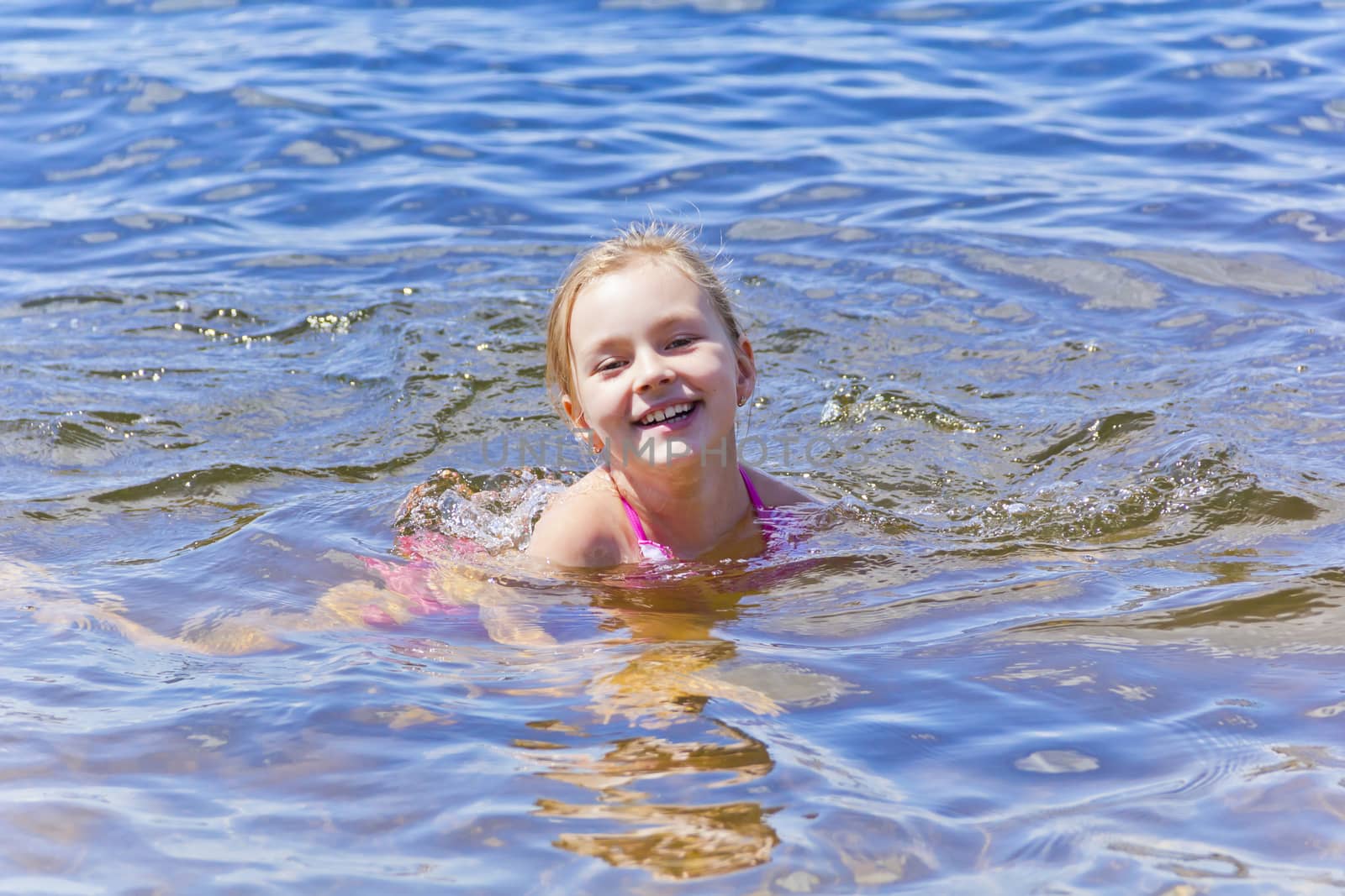 Swimming smiling cute girl seven years old