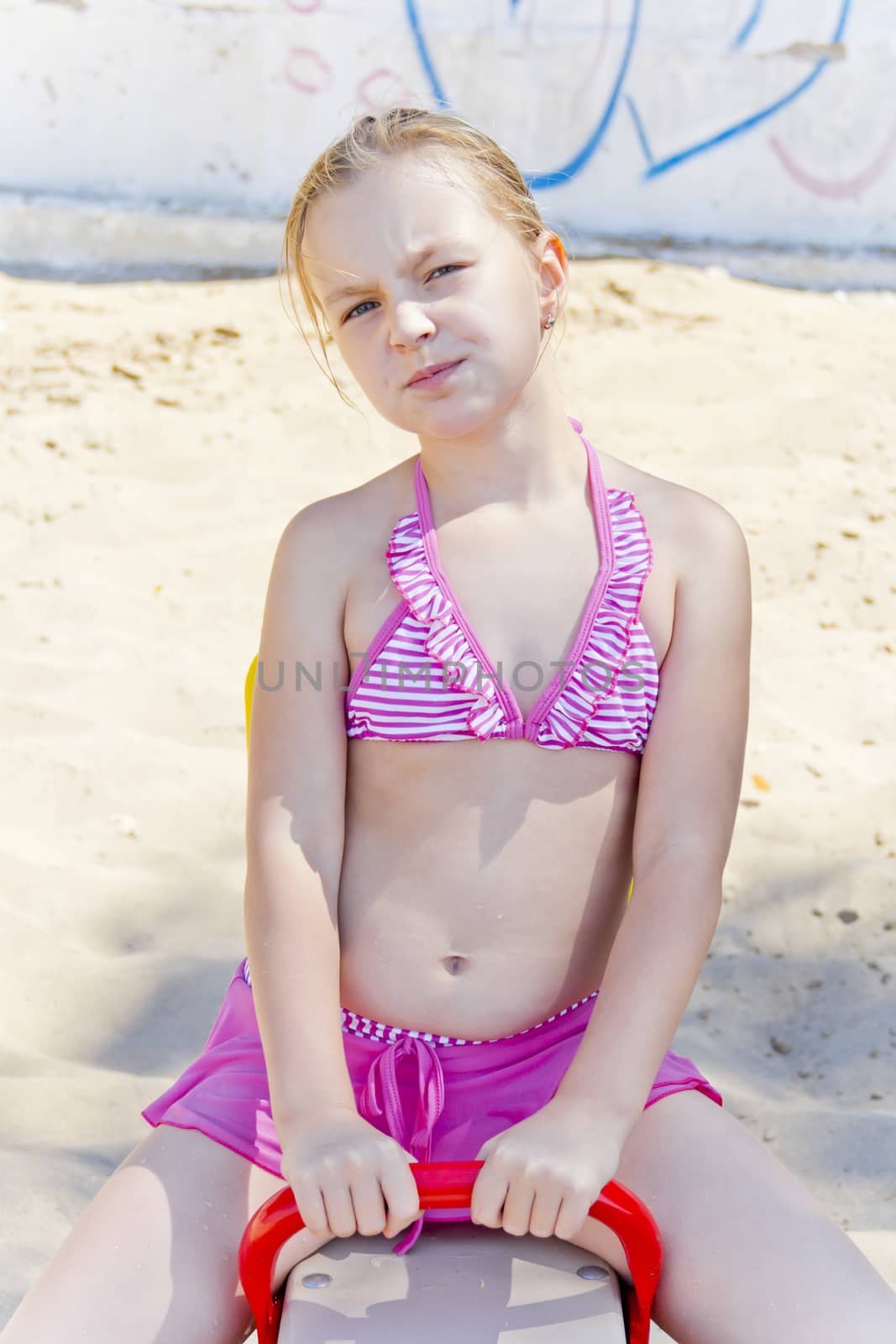 Chewing girl at playground on the beach
