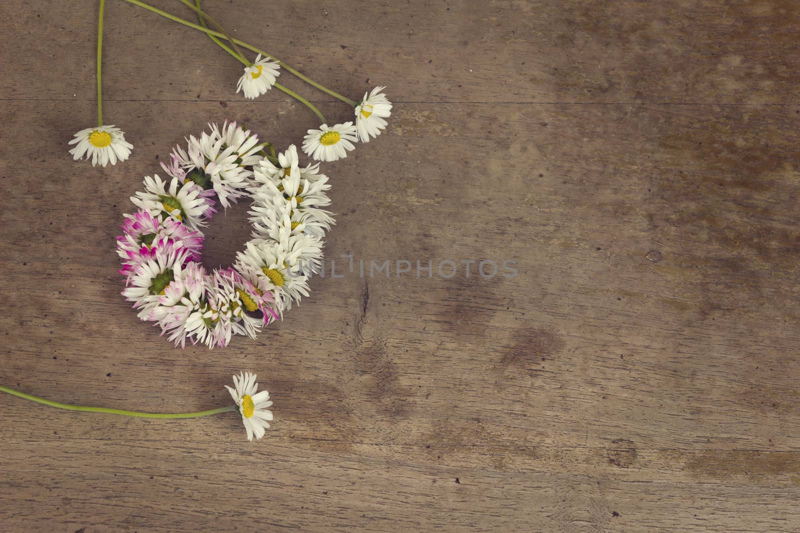 Wreath of daisies on an old wooden table