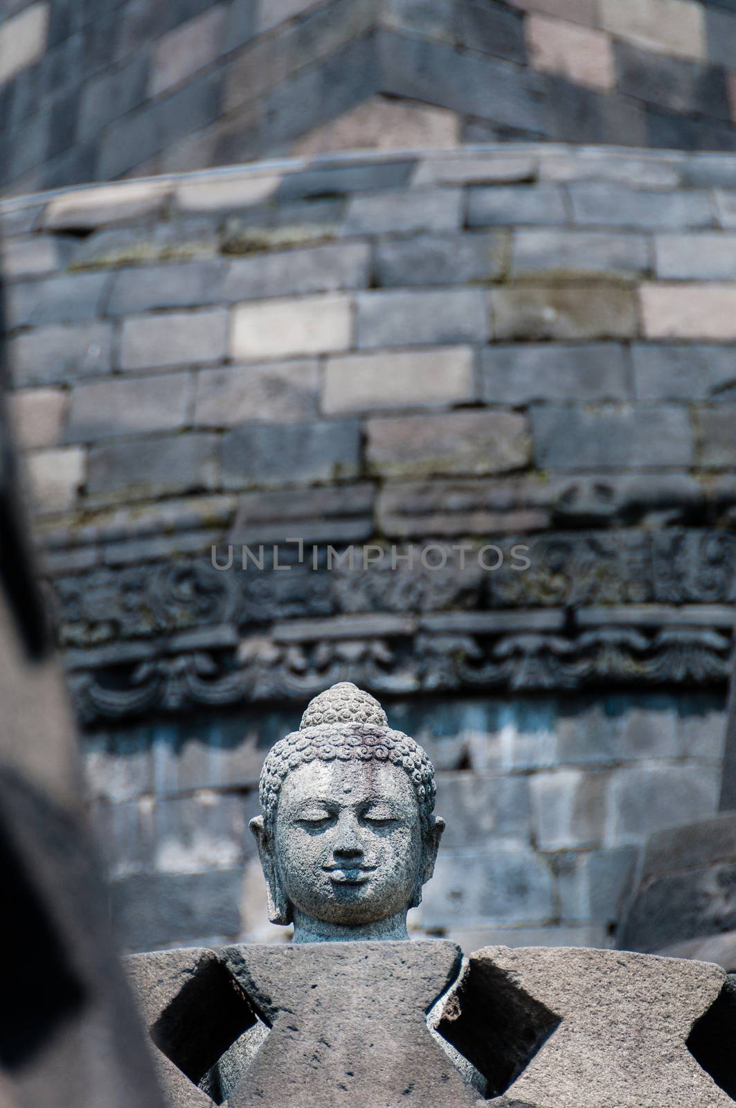 Buddha on the top of Borobudur in a stupa near Yogyakarta, Indonesia. Borobudur is a 9th-century Mahayana Buddhist monument in Central Java, Indonesia.