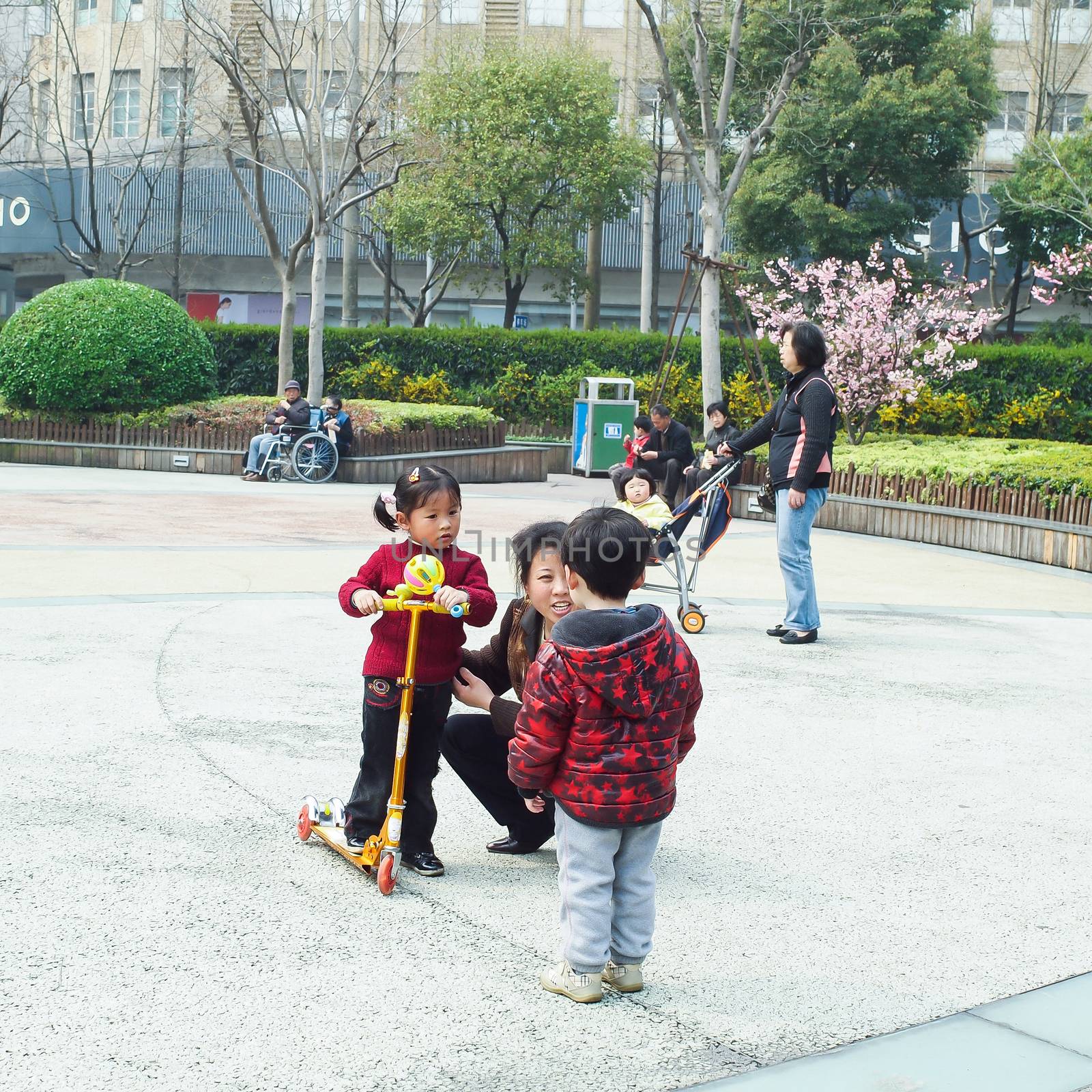 SHIANGHAI, CHINA - April 8, 2011 : Little asian boys and girls playing in the public park with their parents