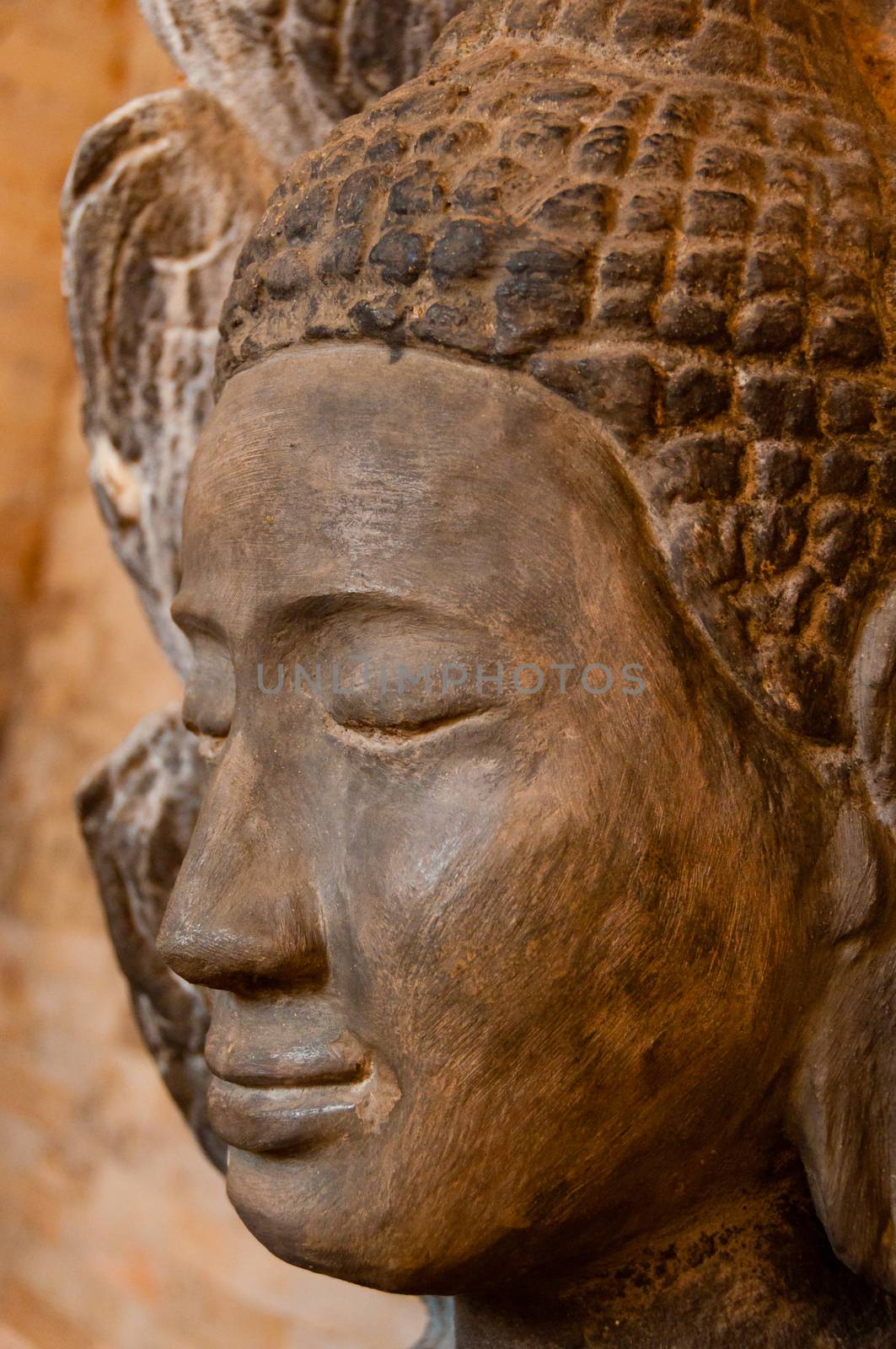 Face front of stone Buddha seen in a temple in Angkor Wat