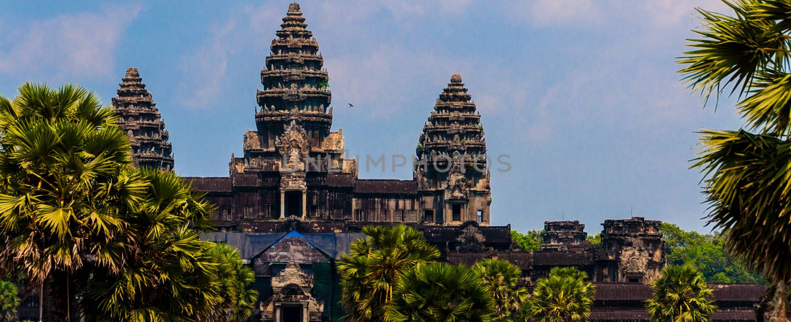 Front of Angkor Wat under cloudscape with blue sky