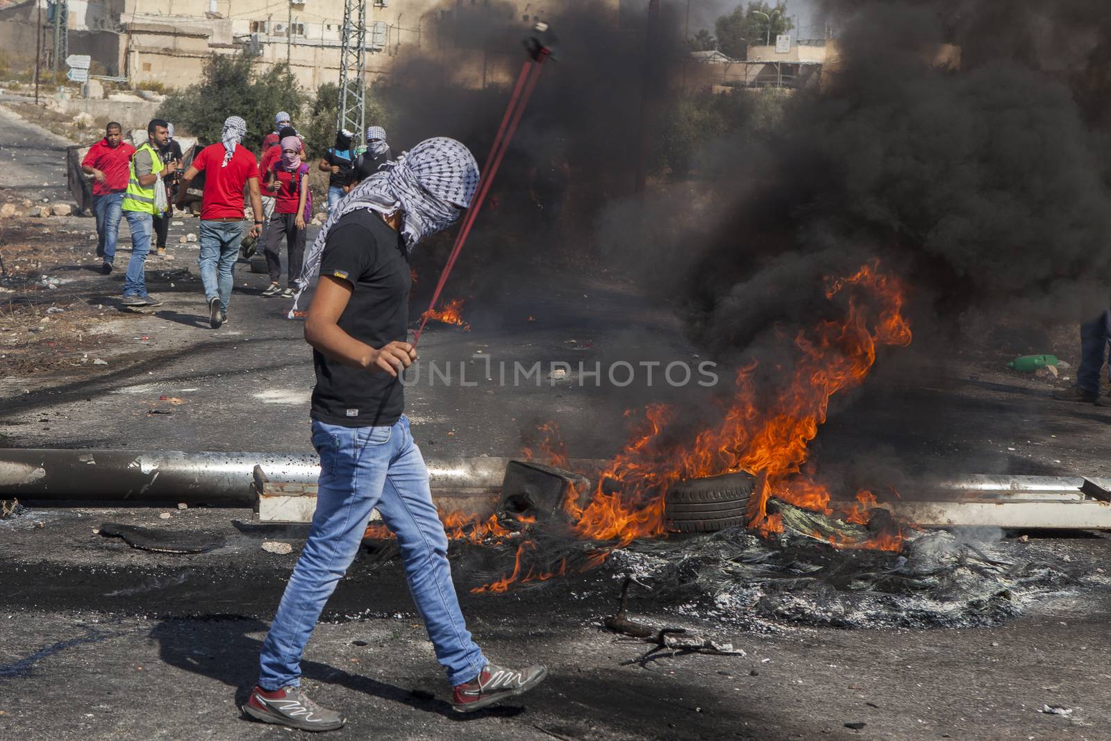 WEST BANK, Ramallah: A Palestinian plays with a slingshot during clashes between the Israeli army and Palestinian youth near the Israeli settlement of Beit El in the West Bank on October 16, 2015.
