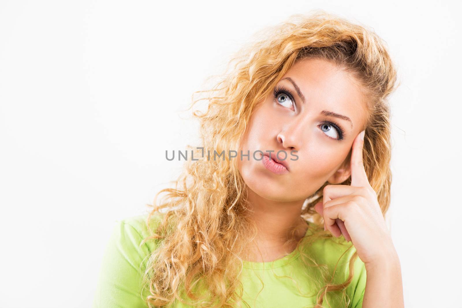 Portrait of beautiful young woman thinking and looking up. Close-up with white background.