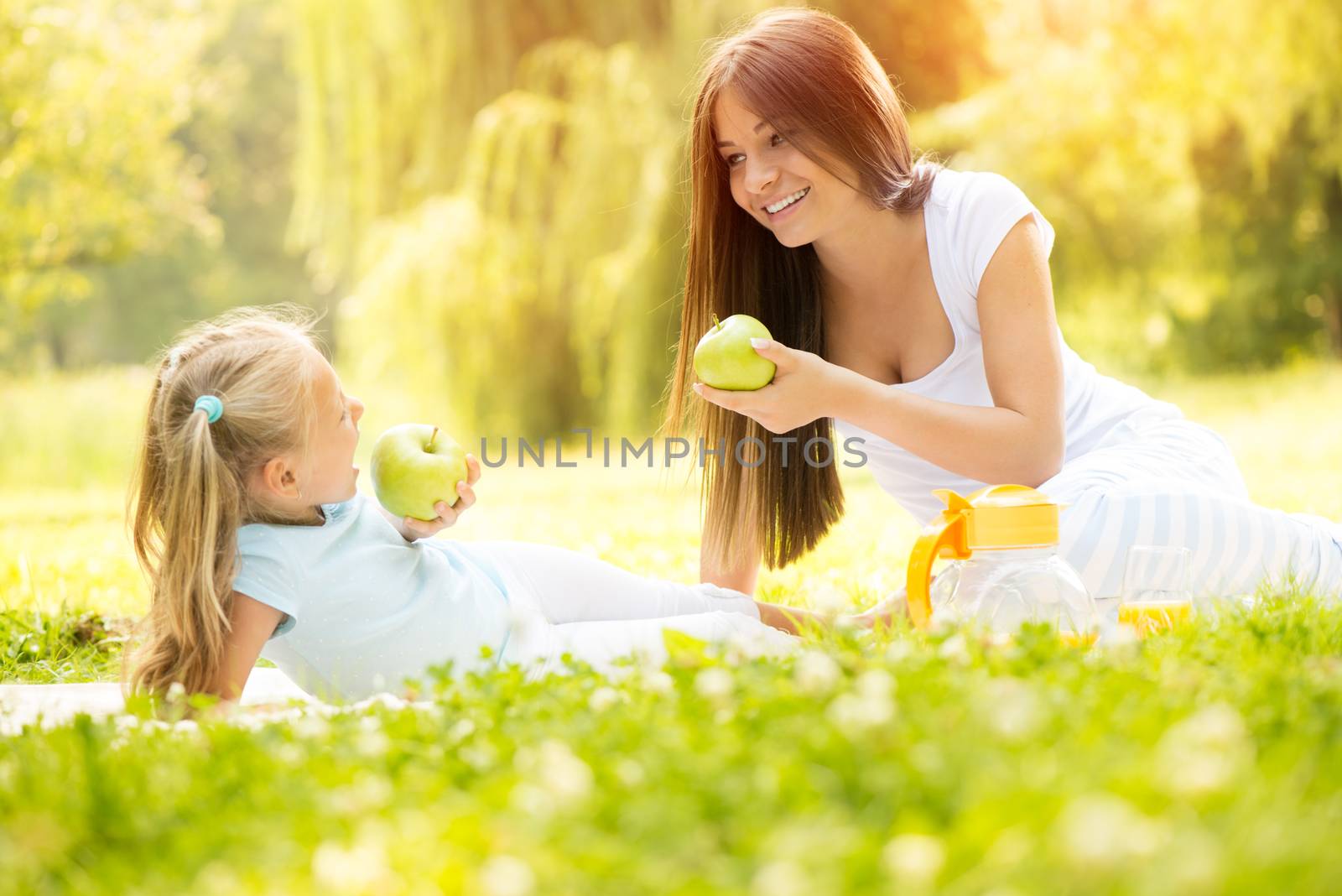 Beautiful Mother and daughter in the nature having little picnic.