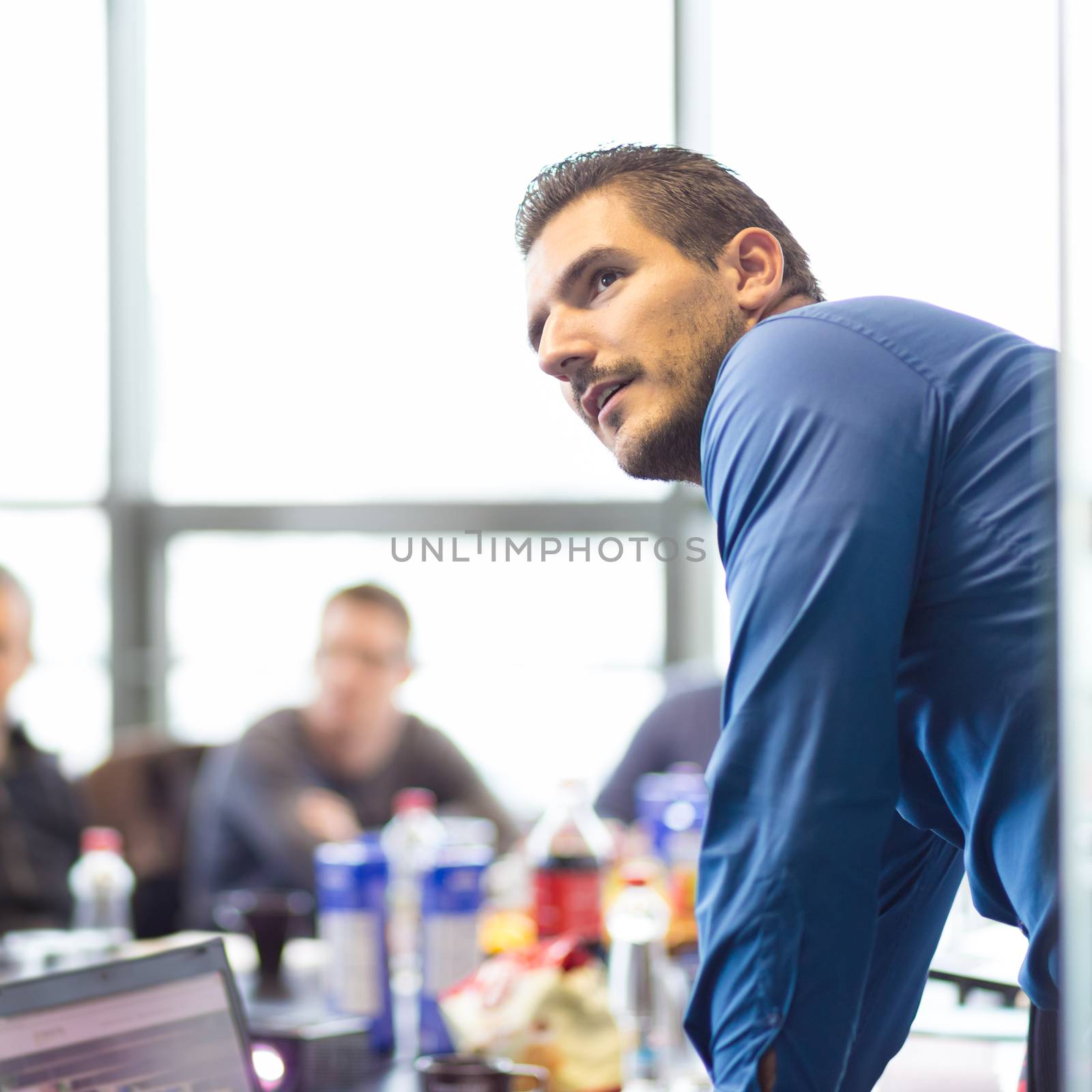 Business man making a presentation at office. Business executive delivering a presentation to his colleagues during meeting or in-house business training, explaining business plans to his employees.