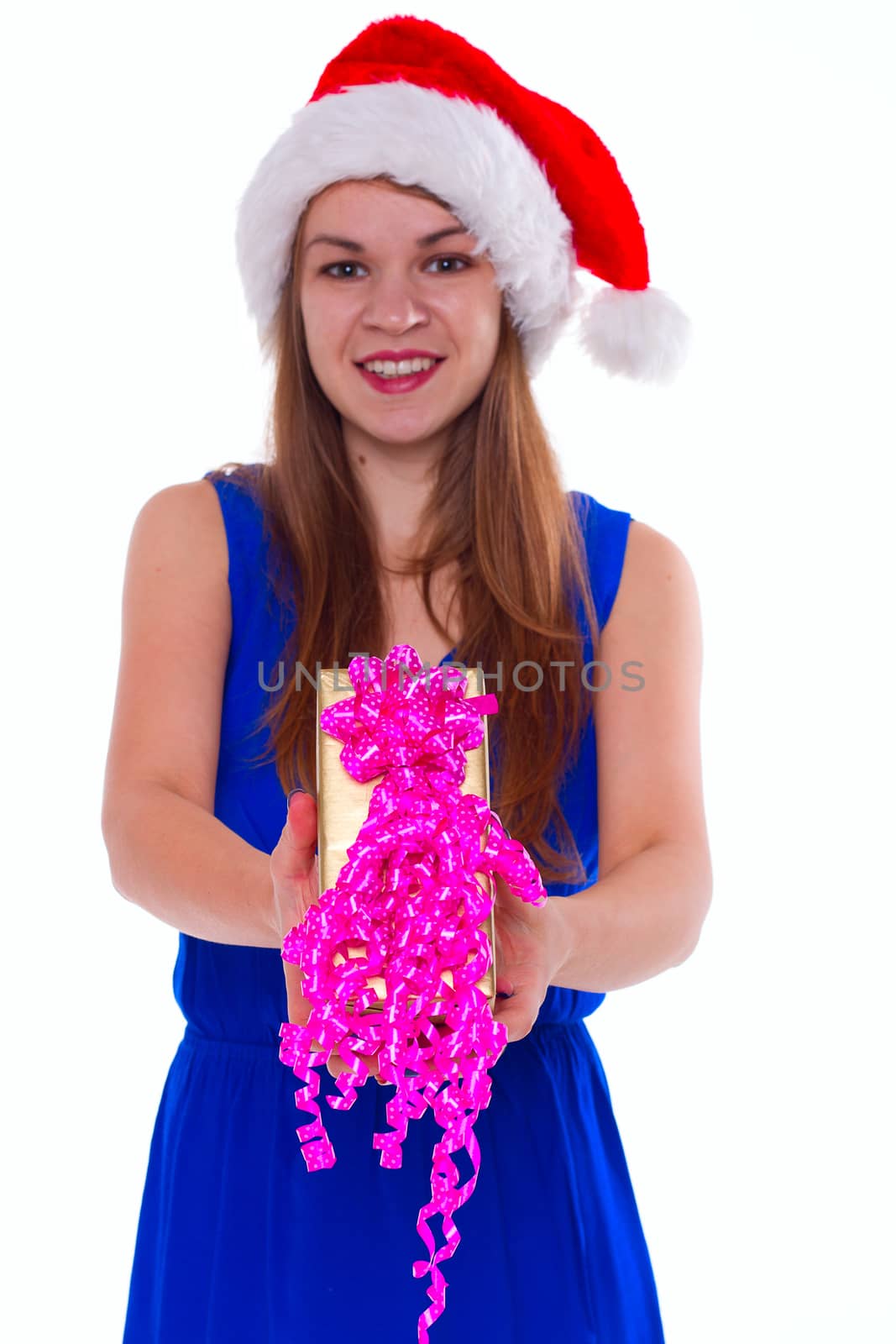 Young happy girl in Christmas hat. Standing indoors and holding huge christmas gift. isolate