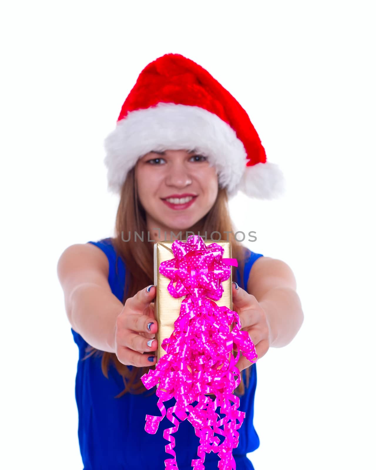 Young happy girl in Christmas hat. Standing indoors and holding huge christmas gift. isolate