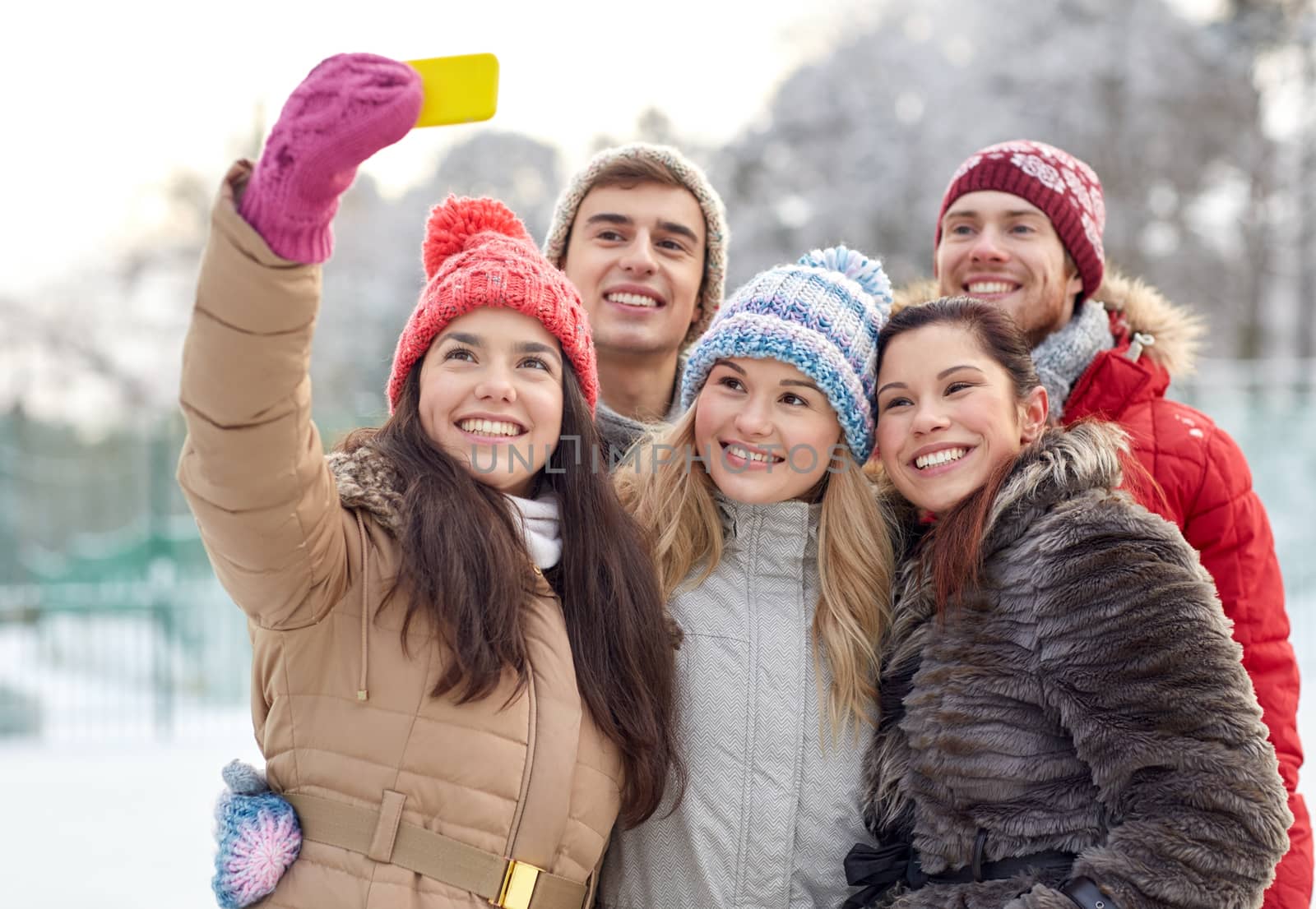 people, friendship, technology, winter and leisure concept - happy friends taking selfie with smartphone outdoors
