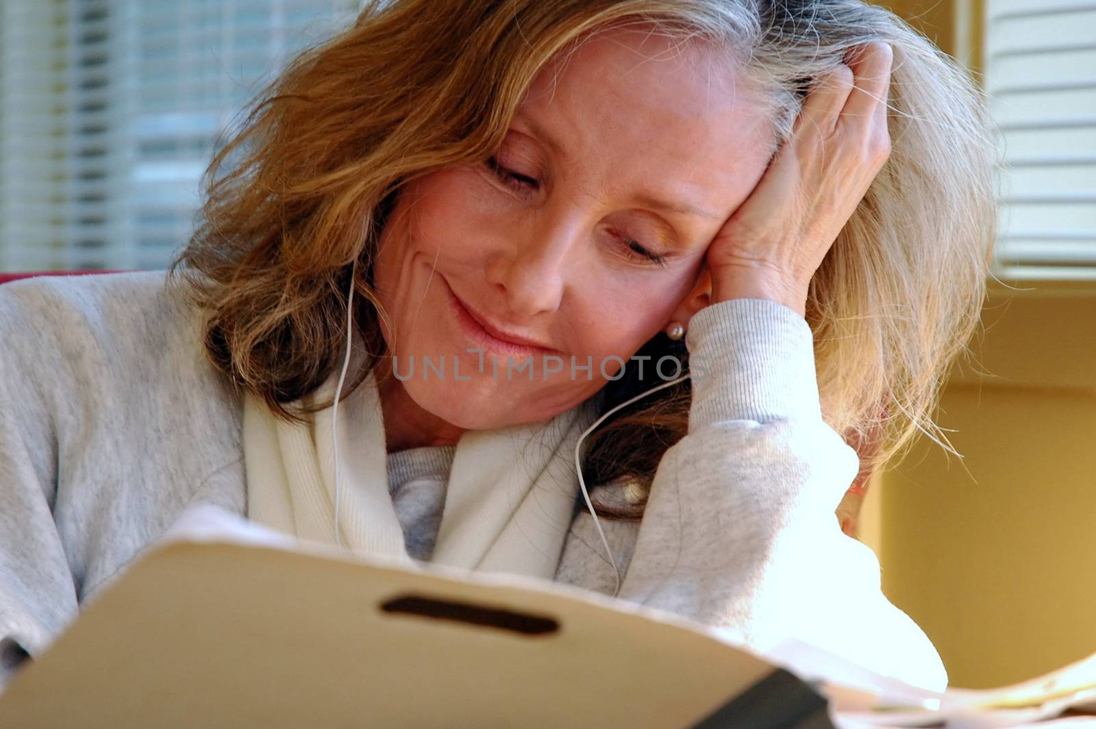 Mature female beauty working overtime in her office.