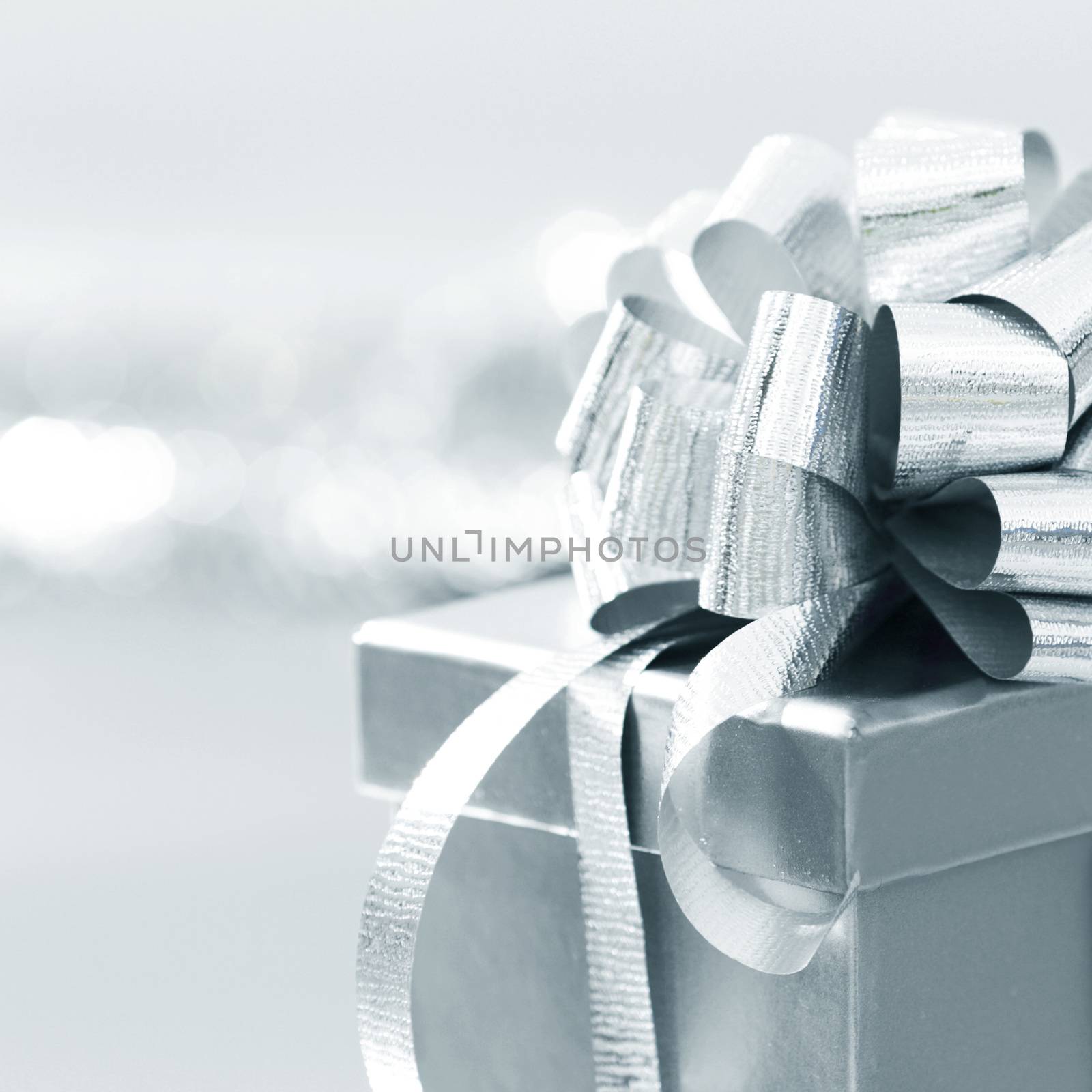 Holiday gift in silver box decorated with ribbon and bow