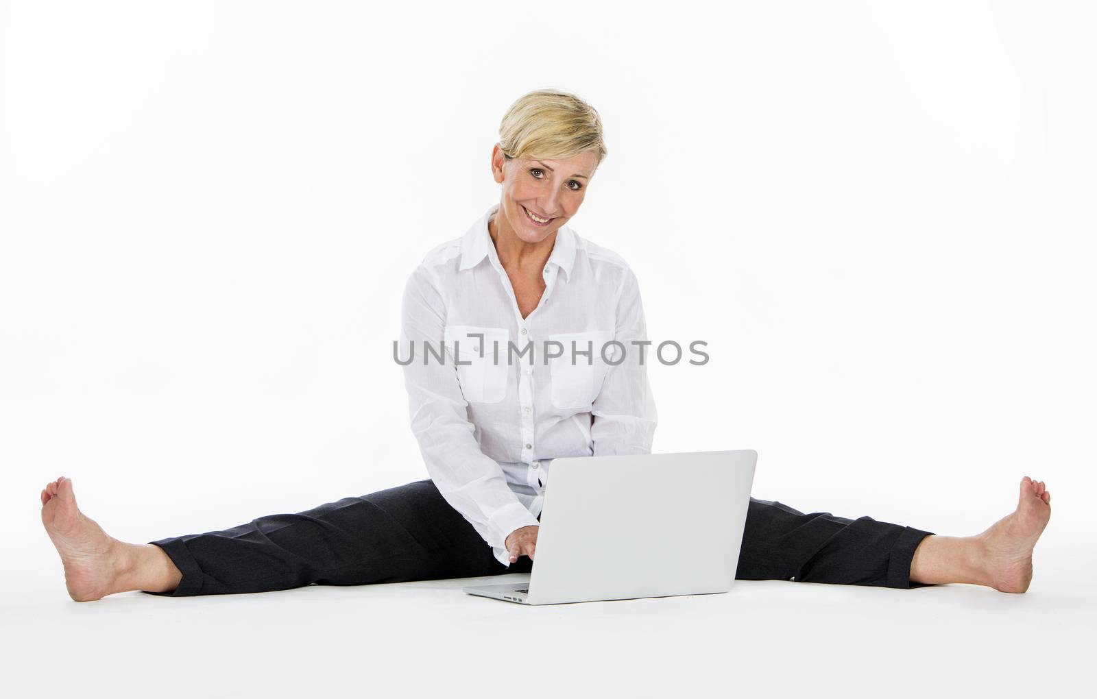 woman manager sat on the floor with laptop by Flareimage