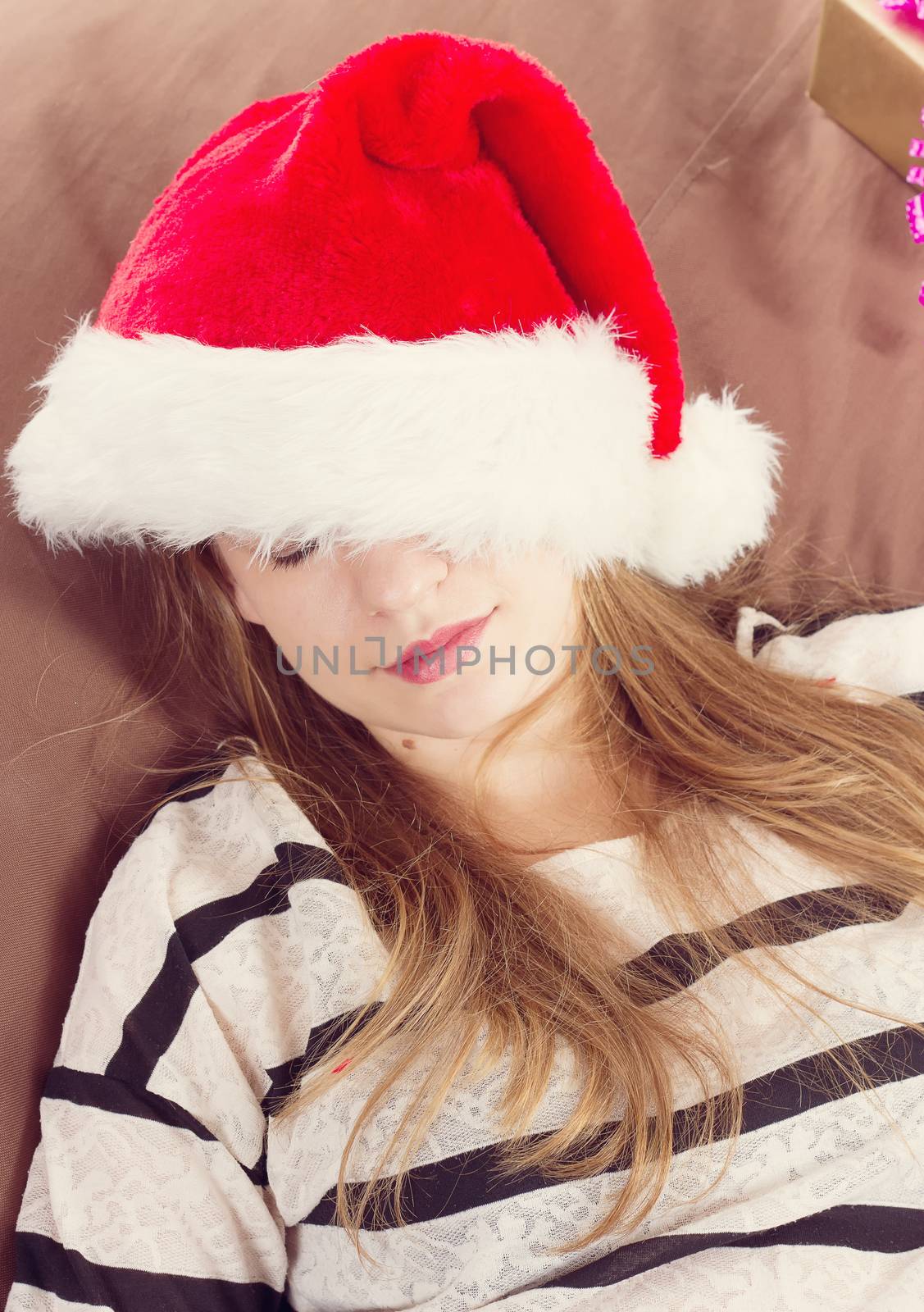 girl in a Christmas hat in the brown chair