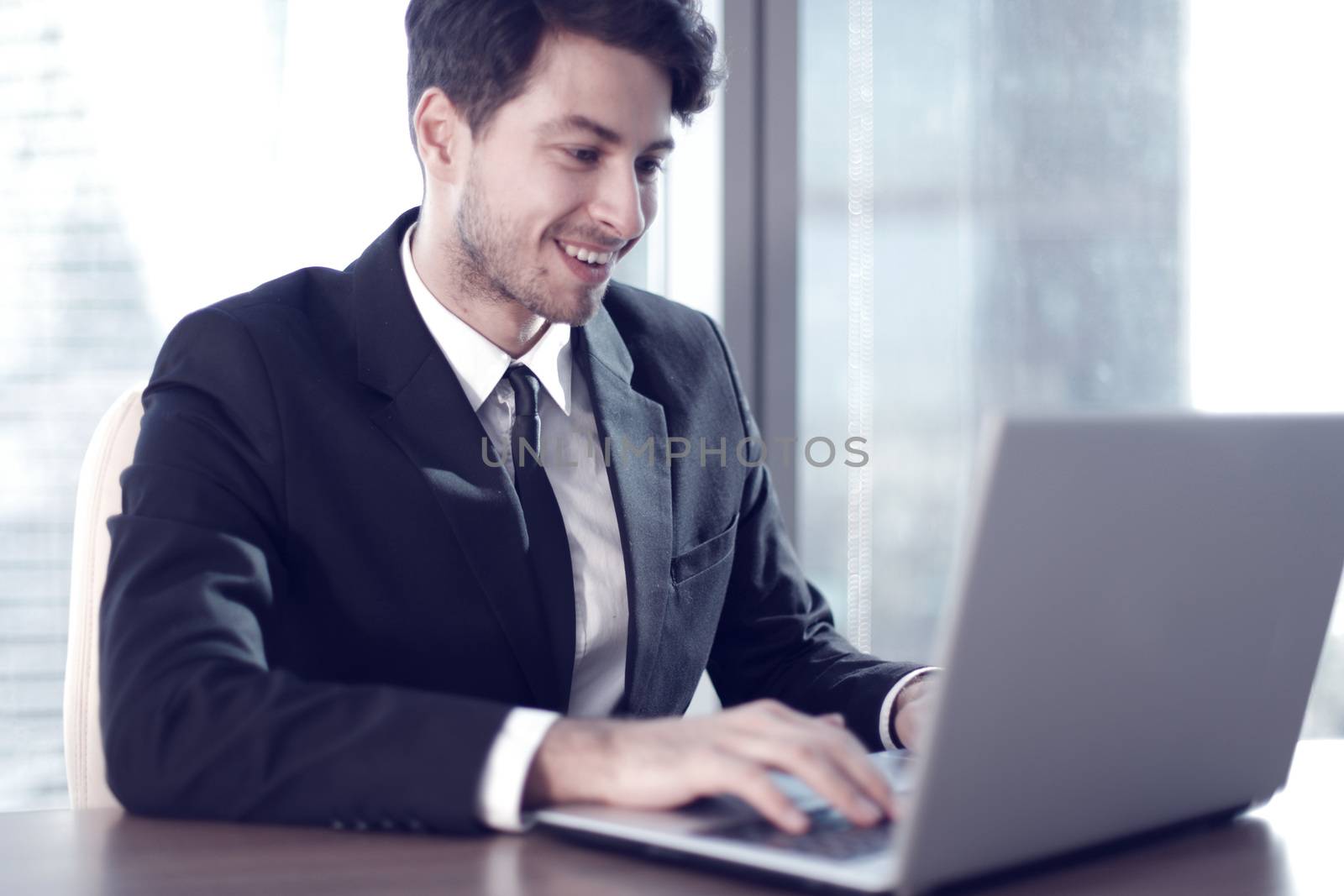 Busy businessman in office working on his laptop.