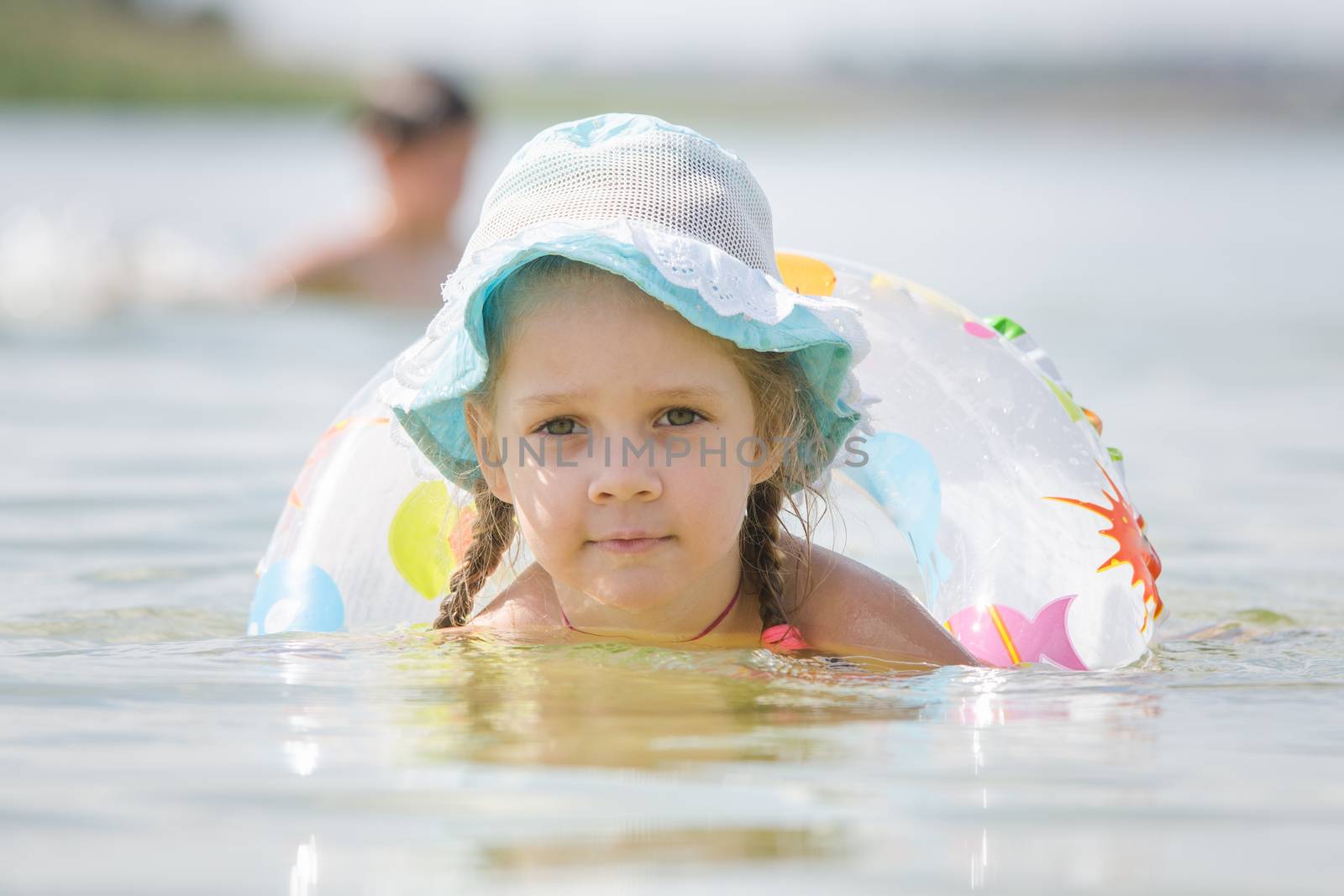 Four-year girl with the Europeans bathed swimming laps in the river