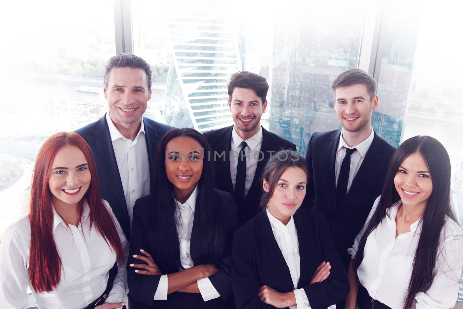 Portrait of business team of men and women in office with view on skyscrapers