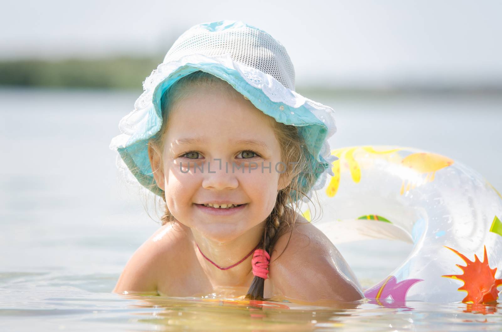 Four-year girl with the Europeans bathed swimming laps in the river