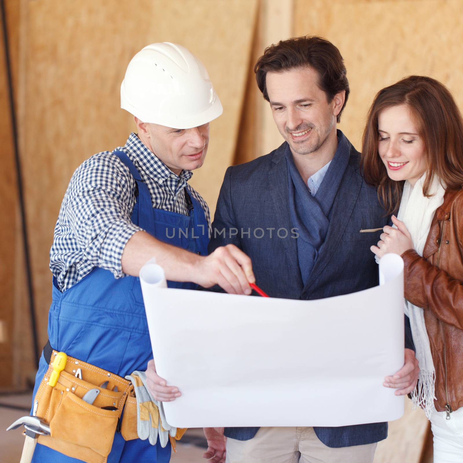 Construction: Young Couple Look At Home Plans with Builder