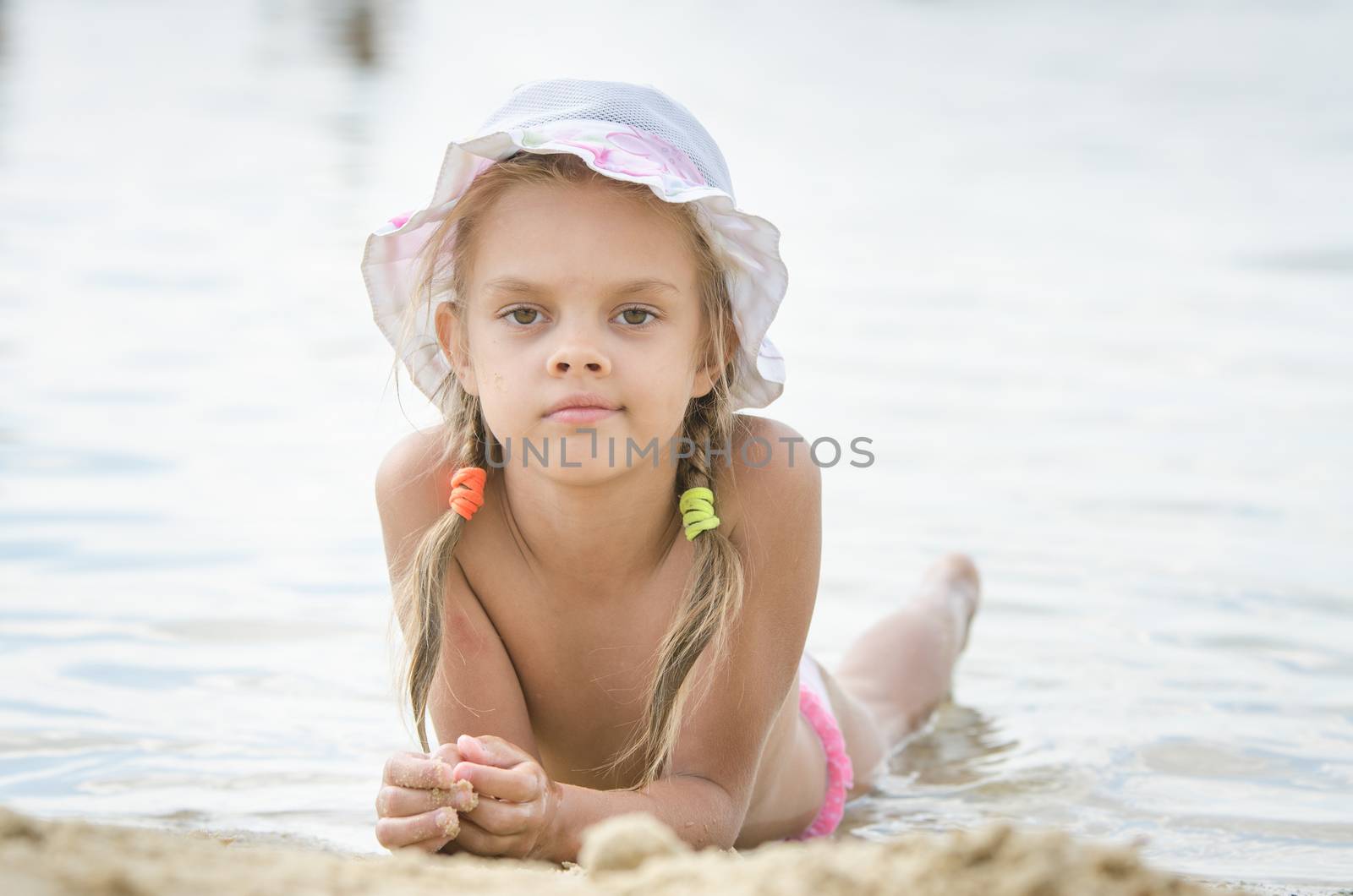 Six year old girl Europeans in panama lying on his stomach on the river bank