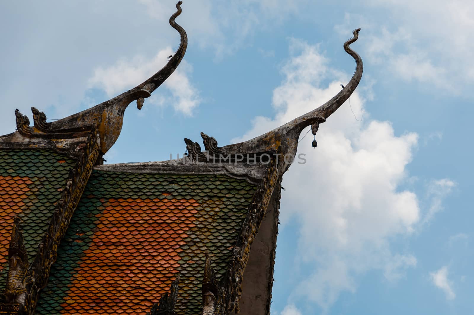 Roof of temple in Laos with blue sky and clouds in close to Luang Prabang