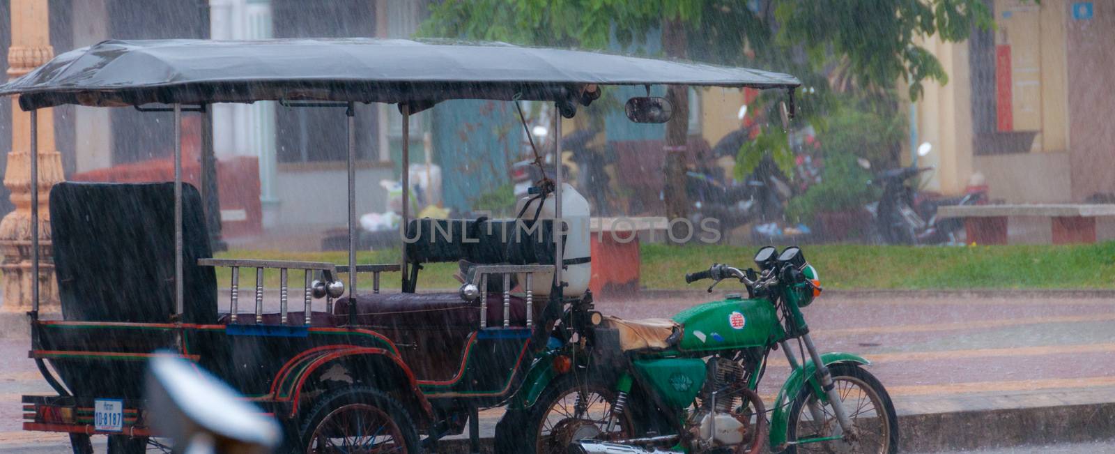 Tuktuk motocycle during rain monsoon in Kampot by attiarndt