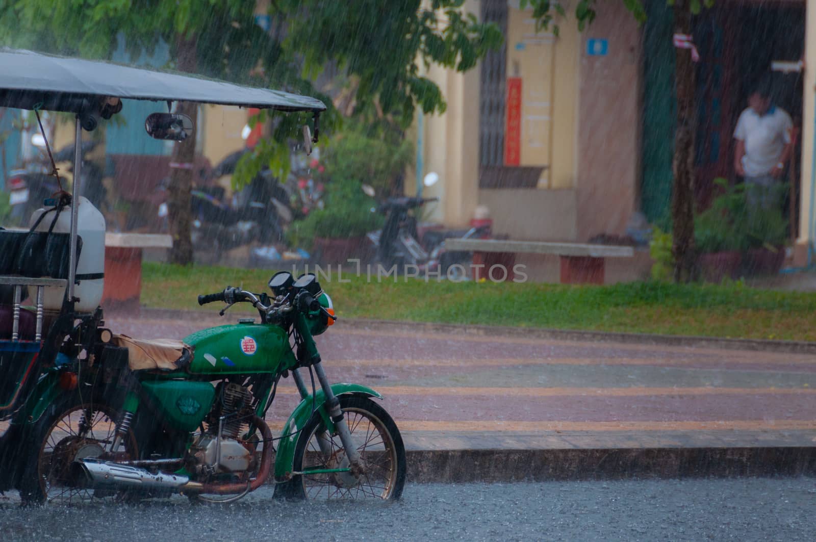Tuktuk motocycle during rain monsoon in Kampot by attiarndt