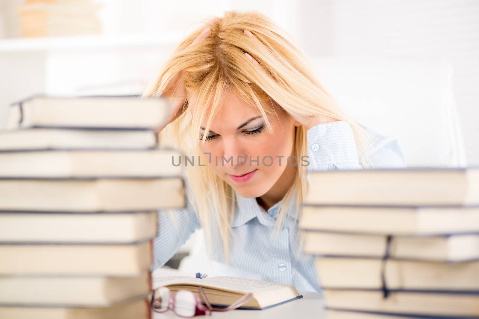 Beautiful Student girl learning between many books. 